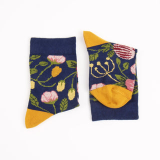 Pair of socks with floral pattern and yellow accents on a white background