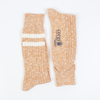 Pair of gold marl socks with a visible brand logo on a white background
