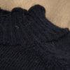 Close-up of dark blue knitted jumper showing the neck detail