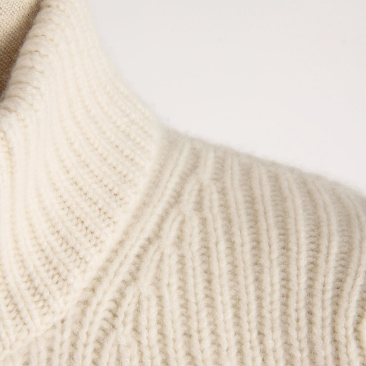 Close-up of beige knitted fabric on a light background