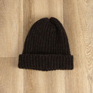 Black knit beanie on a wooden surface
