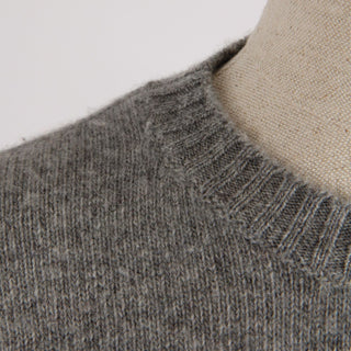 Close-up of a gray knitted sweater collar on a neutral background