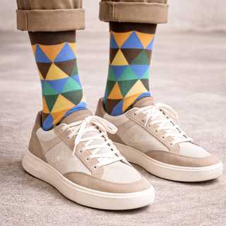 Colourful geometric-patterned sock worn with trainers.