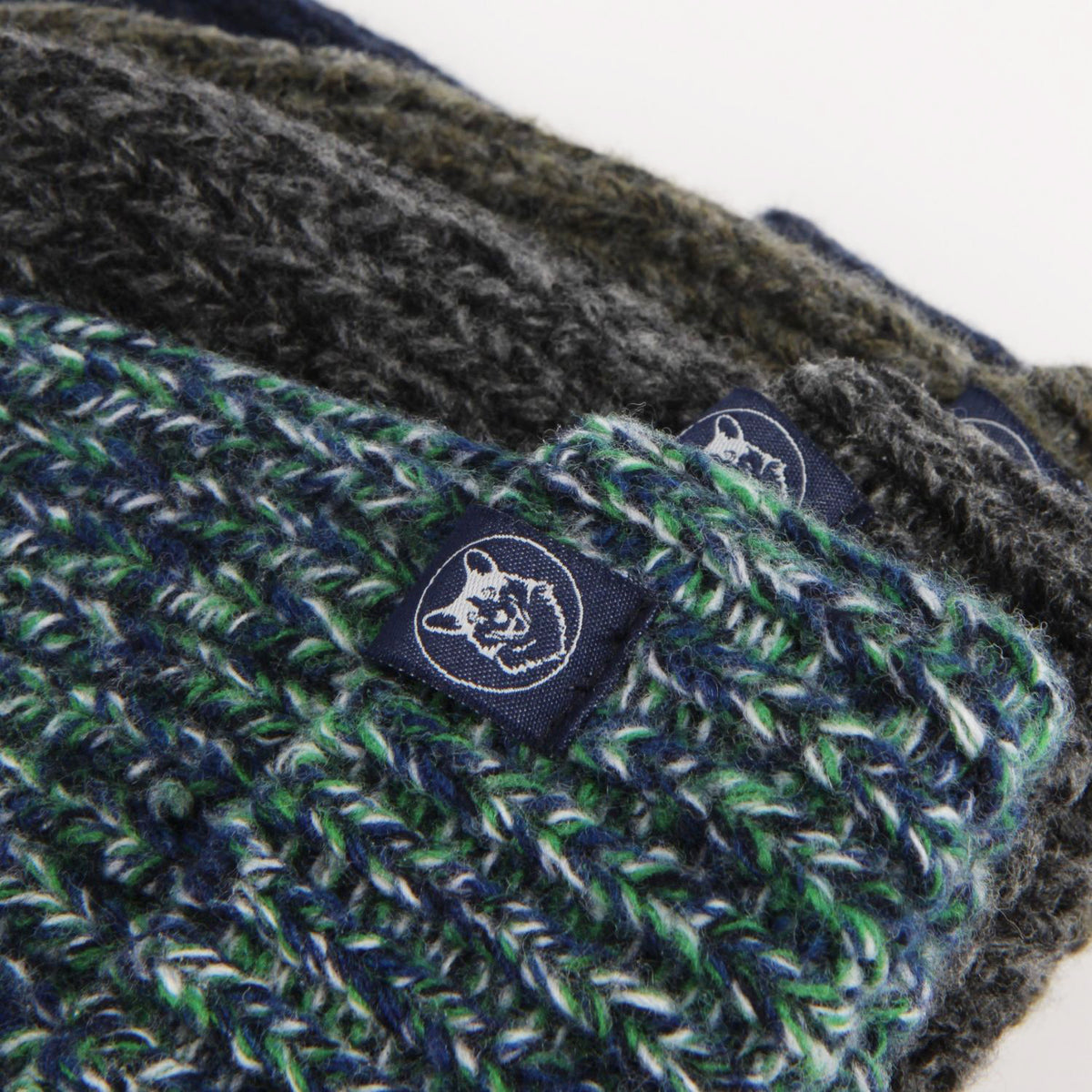 Close-up of a green and gray knitted product with a brand logo on a white background