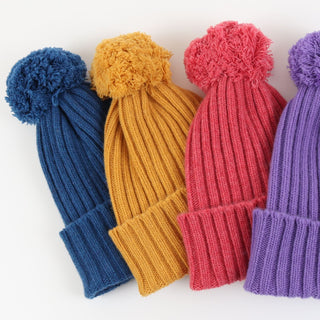 Four colourful knit hats with pom-poms on a white background