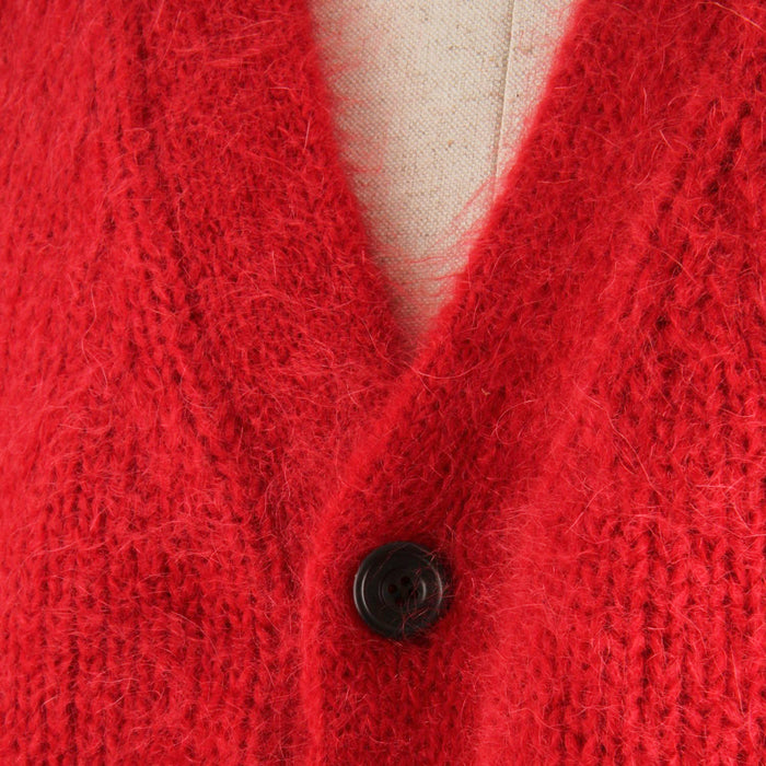 Close-up of a red mohair cardigan with a button