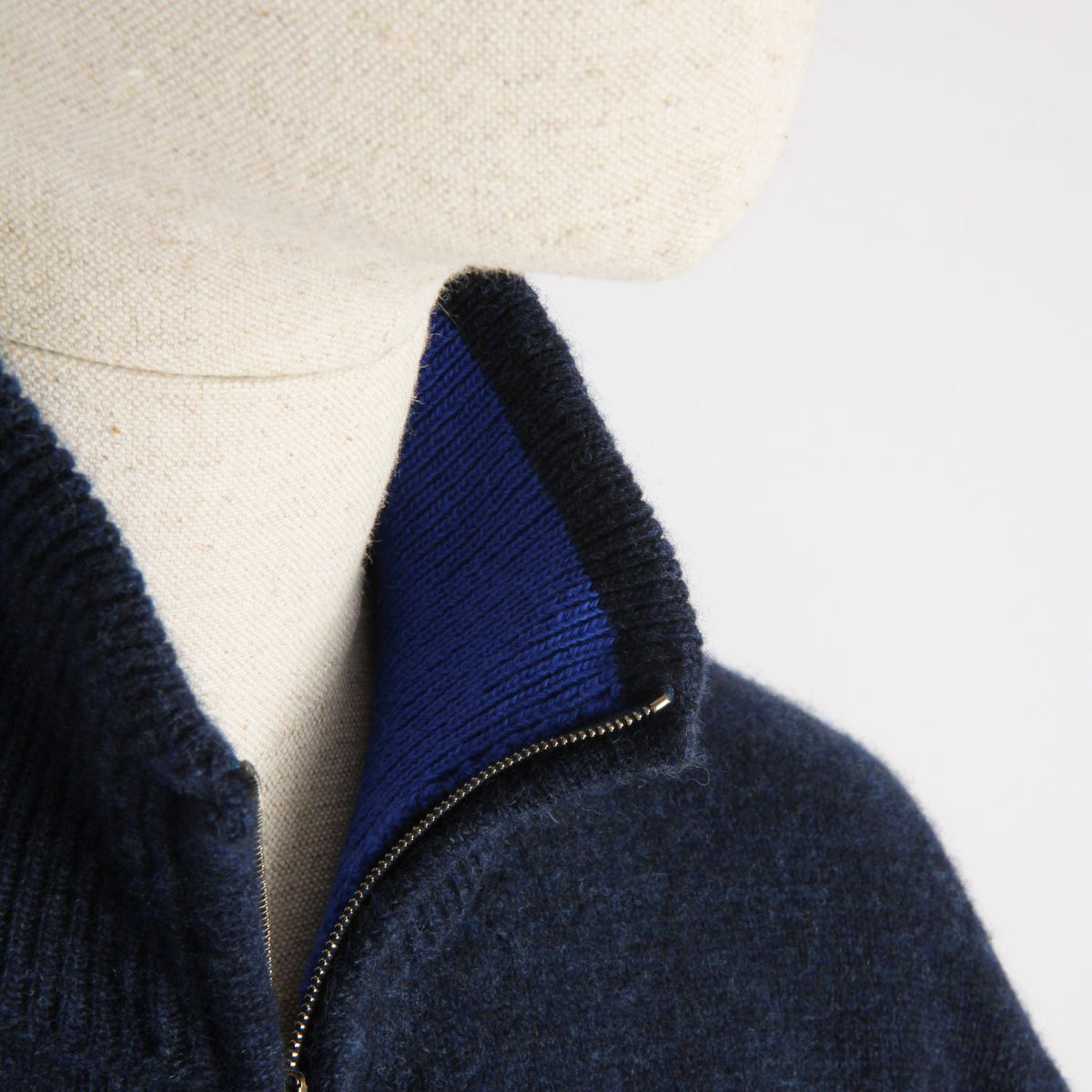Navy blue sweater with a zipper on a mannequin against a white background