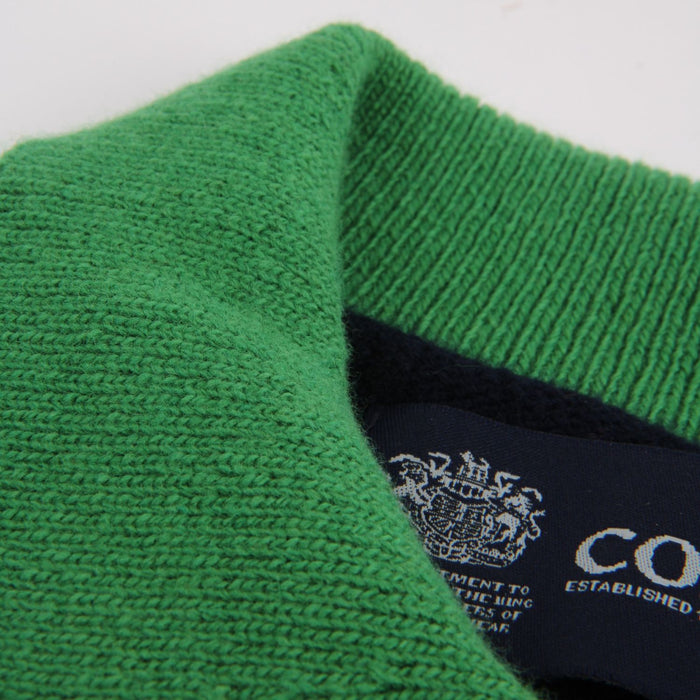 Close-up of a green fabric texture with a brand label in the corner.