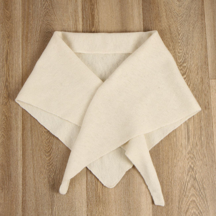 cream triangle scarf folded on a wooden surface