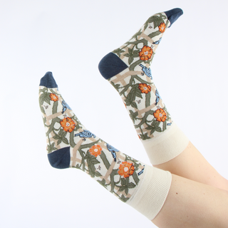 person wearing William Morris trellis design socks with legs in the air