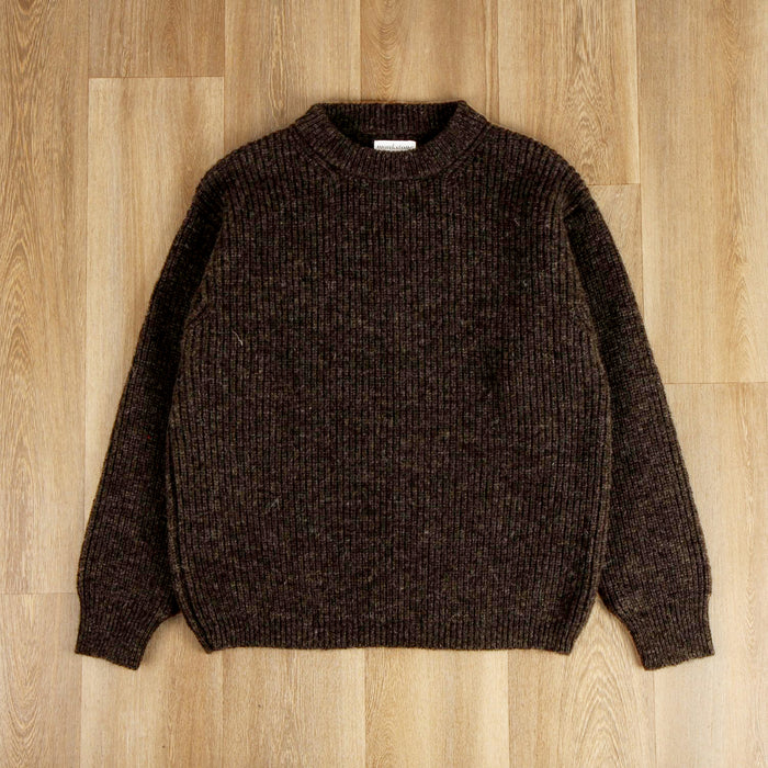 Brown knitted sweater on a wooden floor