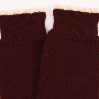 Close-up of maroon knit socks with a white background