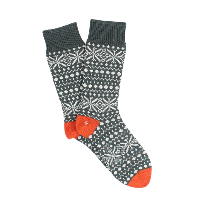 Green sock with white snowflake pattern and orange accents on a white background