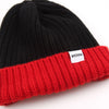 Black and red beanie with a white label on a white background