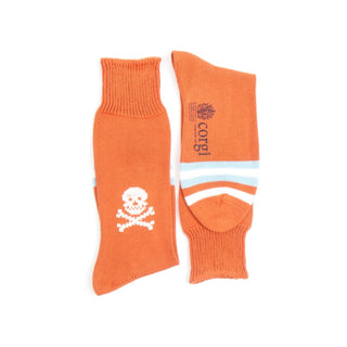 Orange socks with skull and crossbones design and 'corgi' branding on a white background