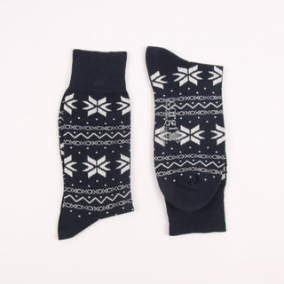 Two navy blue socks with white snowflake patterns on a white background