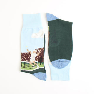 A pair of men's tennis socks with a pattern depicting a tennis player and crowd scene on a light background, with dark green at the cuffs.