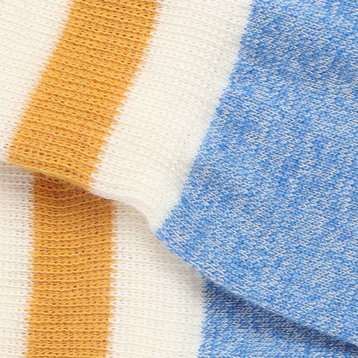 Close-up of fabric with orange, white, and blue stripes.