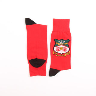 Red socks with a black and green logo on a white background