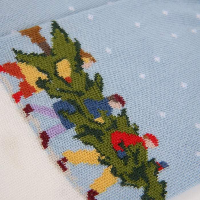 Close up image of three Men carrying a Christmas Tree in the snow on a Cotton Sock