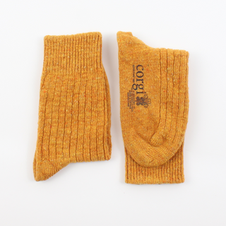 Pair of mustard yellow socks with a brand logo on a white background
