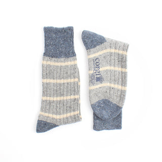 Pair of pale blue socks with cream stripes on a white background