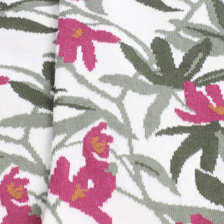 Close-up of fabric with pink floral and green leaf pattern on a white background