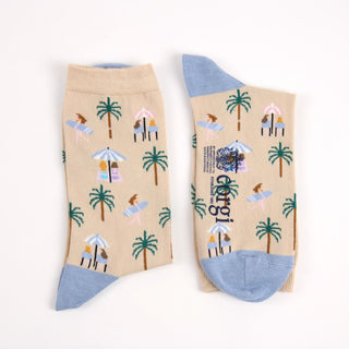 Beige socks with tropical pattern and blue heel and toe photographed on a white background