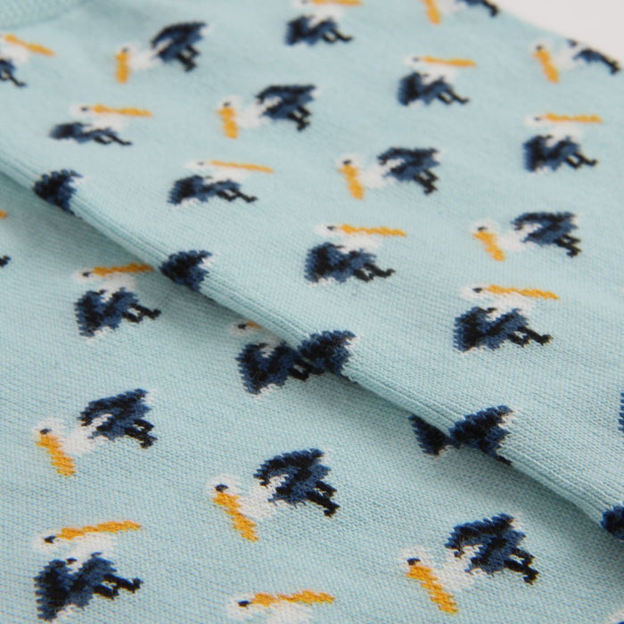 Fabric with mini pelican pattern on a light blue background