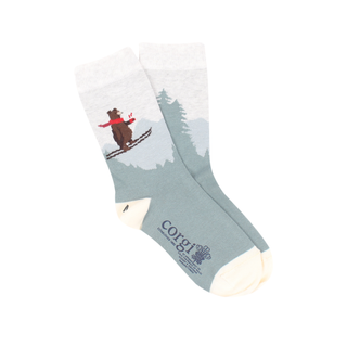A pair of kids' socks with a skiing bear design, placed against a Christmas-themed backdrop with holiday ornaments.