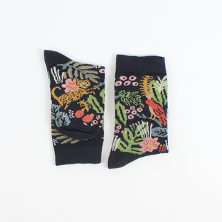 A pair of children's cotton socks with a jungle-themed pattern including colourful plants, flowers, and animals like leopards and birds on a navy background.