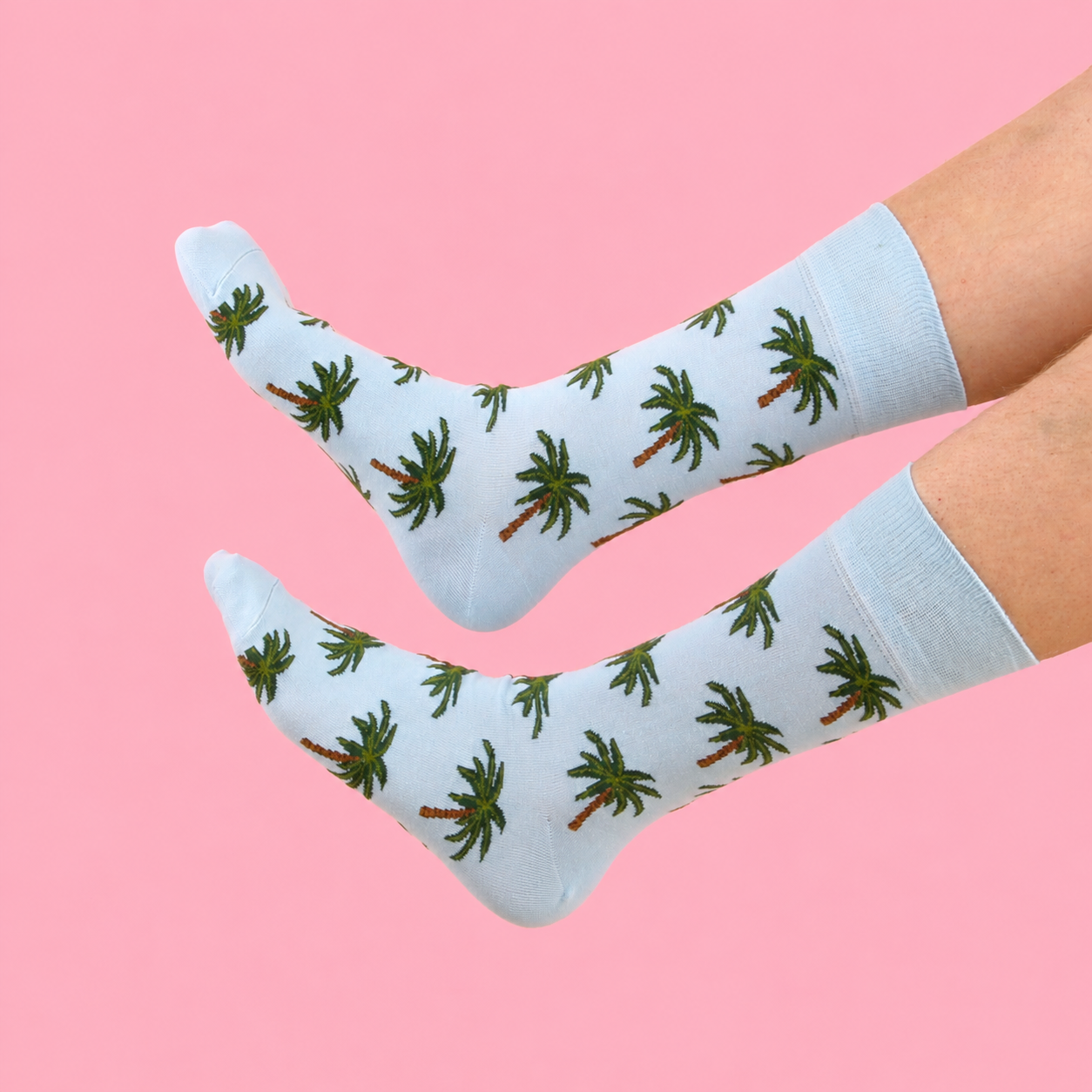 Blue socks with palm tree pattern on a pink background