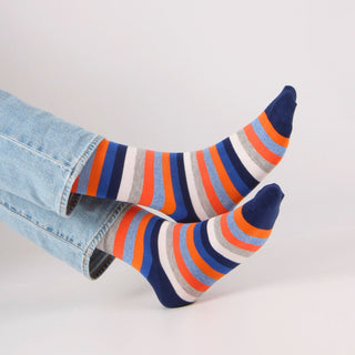 Colorful striped socks with blue jeans on a light gray background