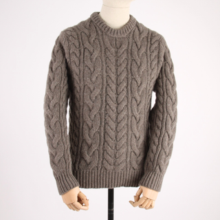 Brown cable knit sweater on a mannequin against a white background