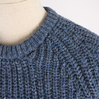 Close-up of a blue knitted sweater on a mannequin.