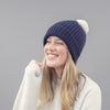 person wearing navy hat with white pom pom