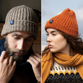 Two models wearing ribbed knit beanie hats. One hat is beige and the other is orange, both with a tweed fleck throughout and a folded brim.