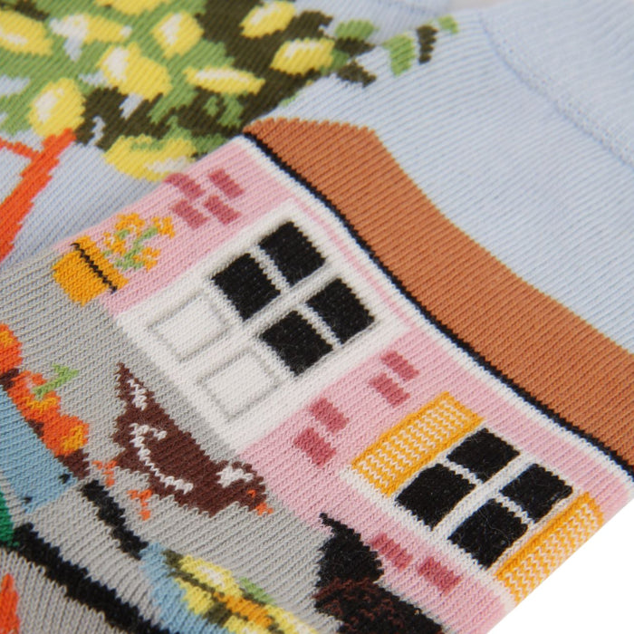 Socks with a colourful design of a house, chickens, and trees on a light blue background.