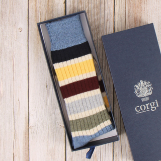 Colorful striped sock in a Corgi branded box on a wooden surface
