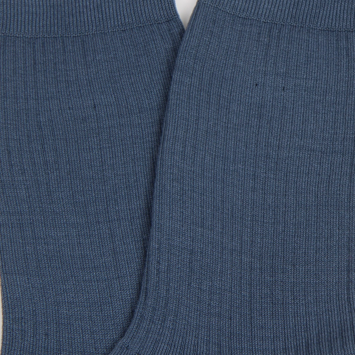 Close-up of blue ribbed fabric with a white background