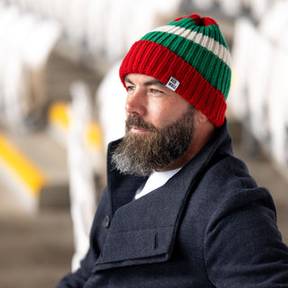 Man wearing the red wall beanie hat in the football stands.