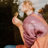 Woman eating a cookie with a blurred natural background