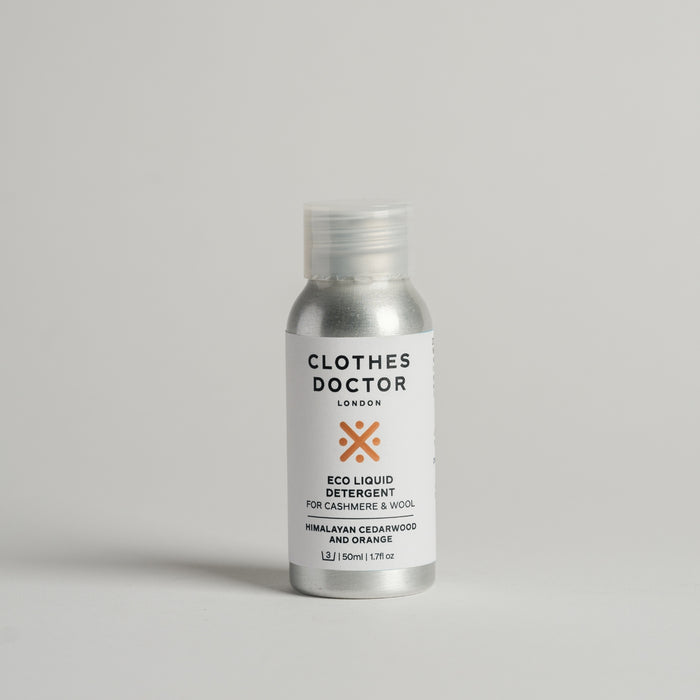 A travel-sized 50ml bottle of Cashmere & Wool detergent by The Clothes Doctor, with a white label and orange accents, on a light background.