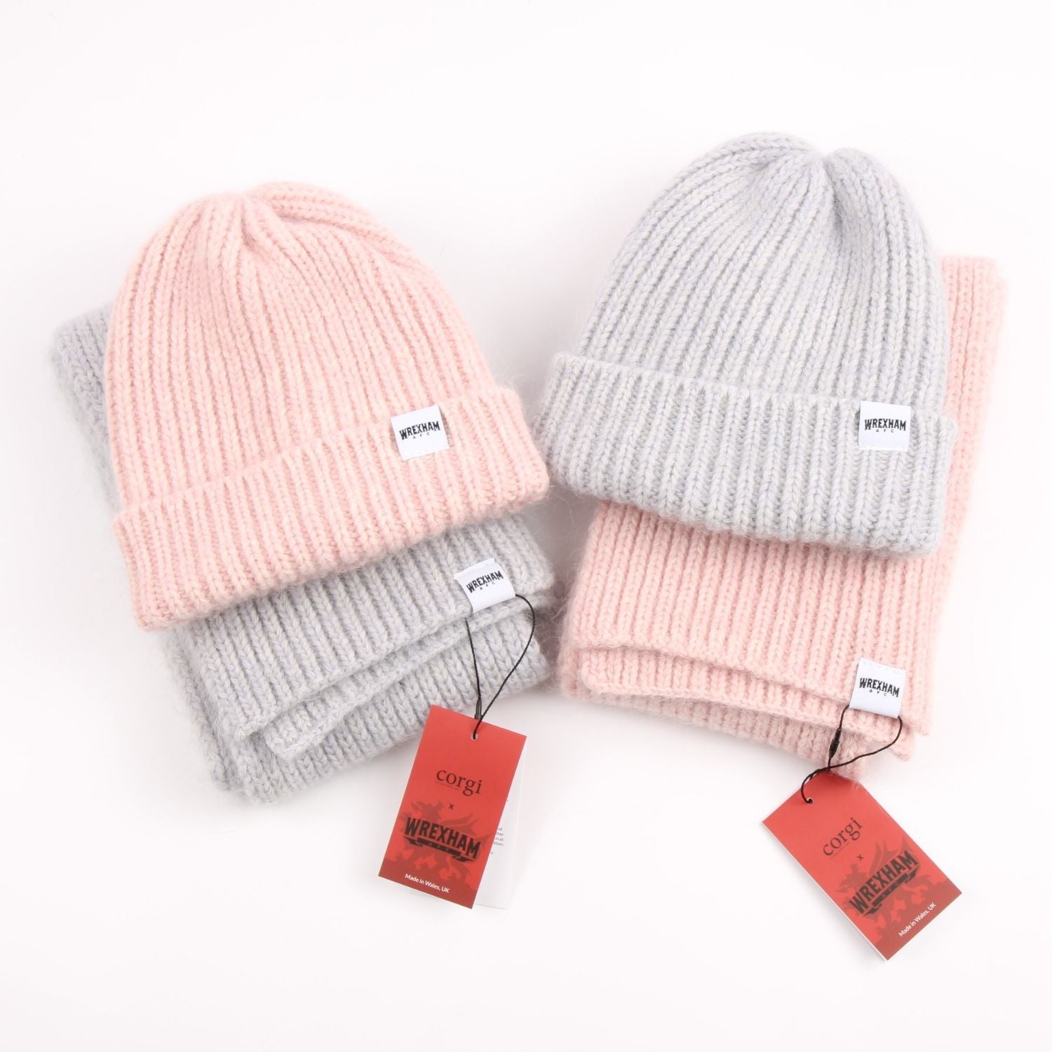 Two pairs of pink and gray knit hats with tags on a white background