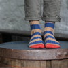 Person wearing striped socks with a rustic background