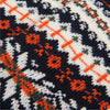 Close-up of a knitted fabric with a geometric pattern featuring navy, orange, and white colours.