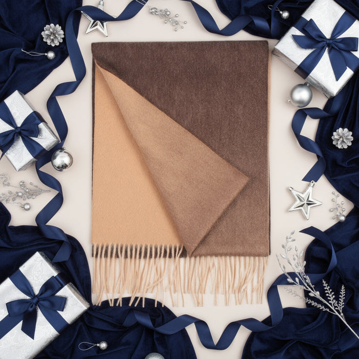 A woven cashmere scarf in ombre color with a geometric triangle shape on a white background, featuring a fringe at the bottom.