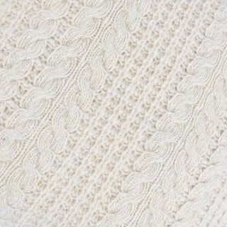 Close-up of a textured white fabric with a cable knit pattern