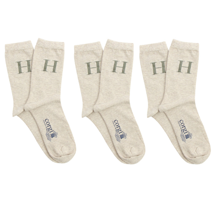 Set of beige socks with 'H' letter on a white background