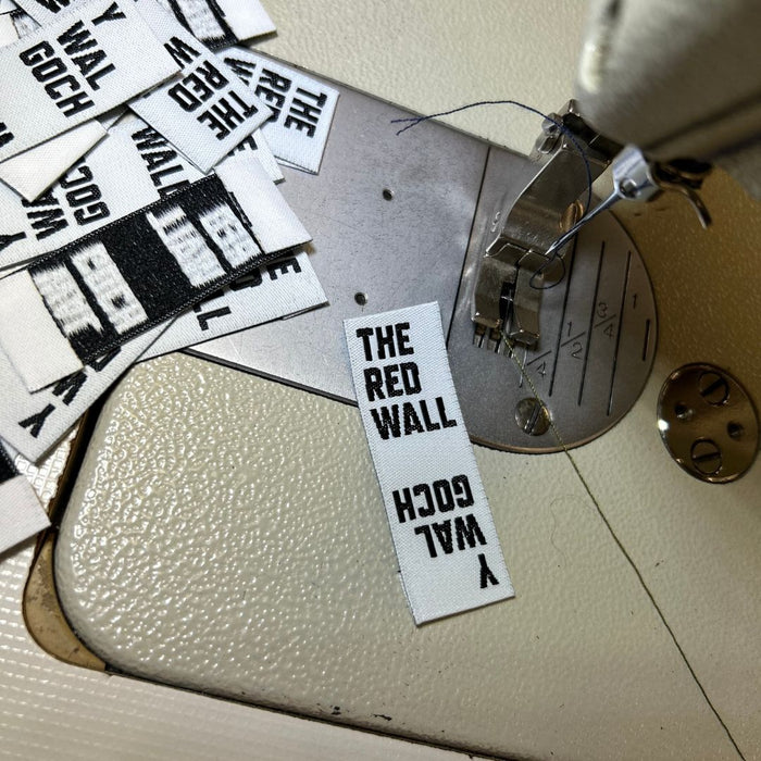 The Red Wall woven tabs on a sewing machine.